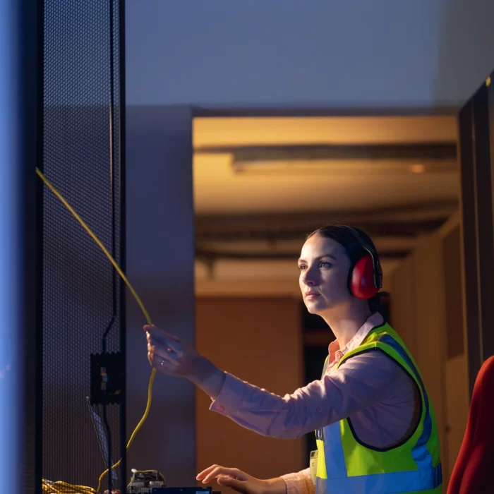 caucasian-female-engineer-touching-a-wire-in-compu-2025-04-03-14-38-38-utc